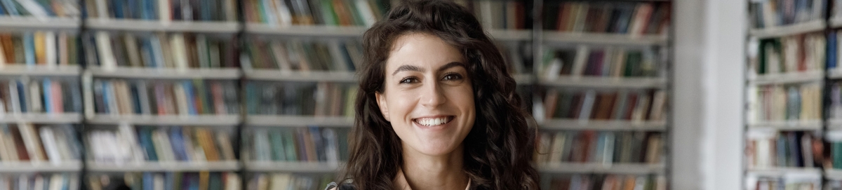 Smiling female college student in the library