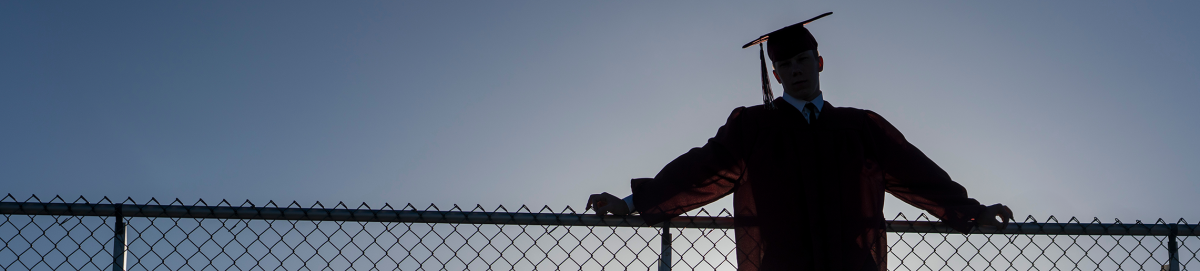 high school graduate standing at the top of the bleachers.
