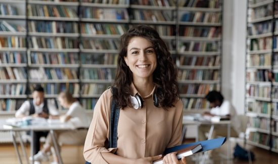 Smiling female college student in the library