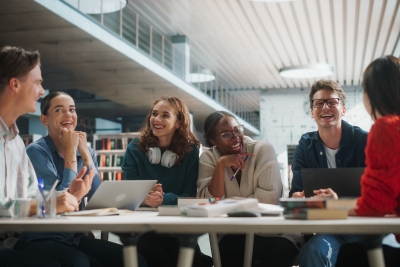 Group of diverse college students smiling while meeting.