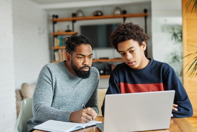 Father and son looking at the laptop.